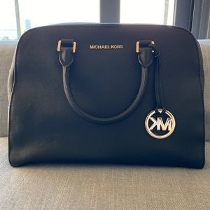 Black Michael Kors bag with key holder and extra chain.